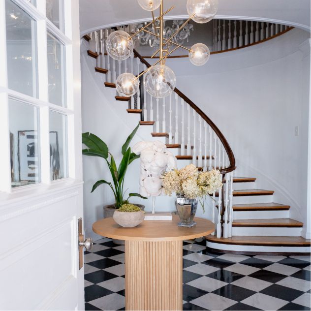 Black and white checkered floor with a white staircase, creating a stylish backdrop for Doula Opportunities.