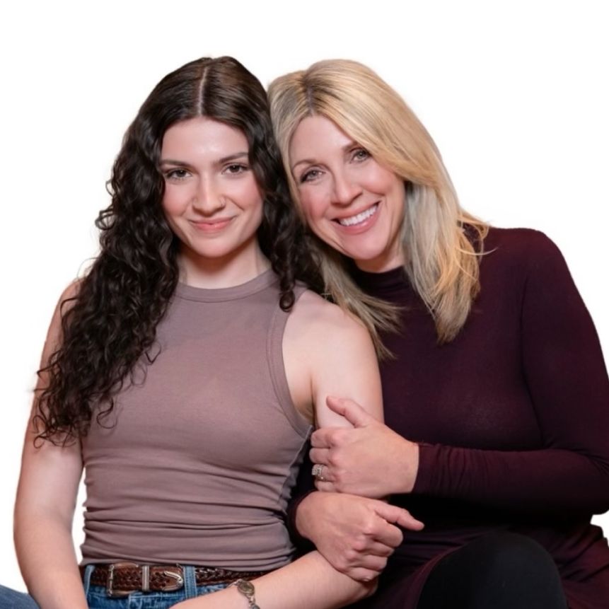 Two women sitting together on a couch, engaged in conversation during a Doula Training Team session.