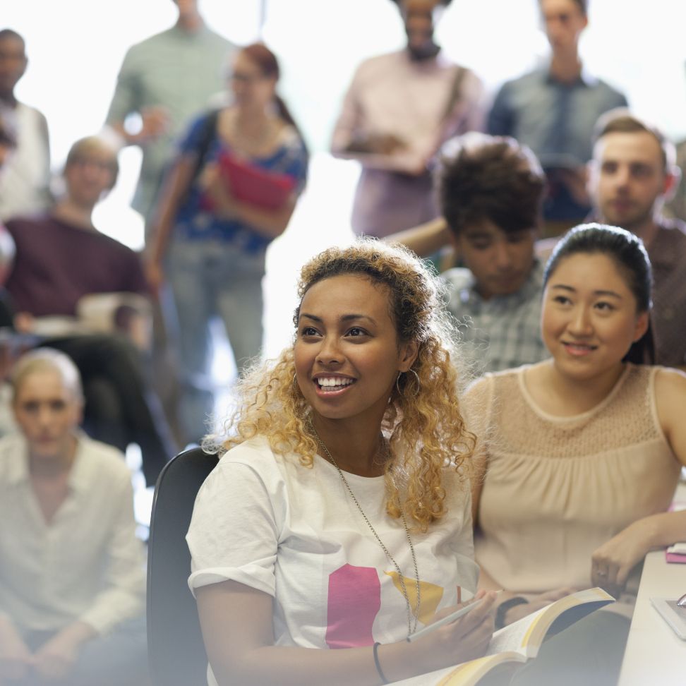 A diverse group of people engaged in discussion at a table during a Doula Training Course.
